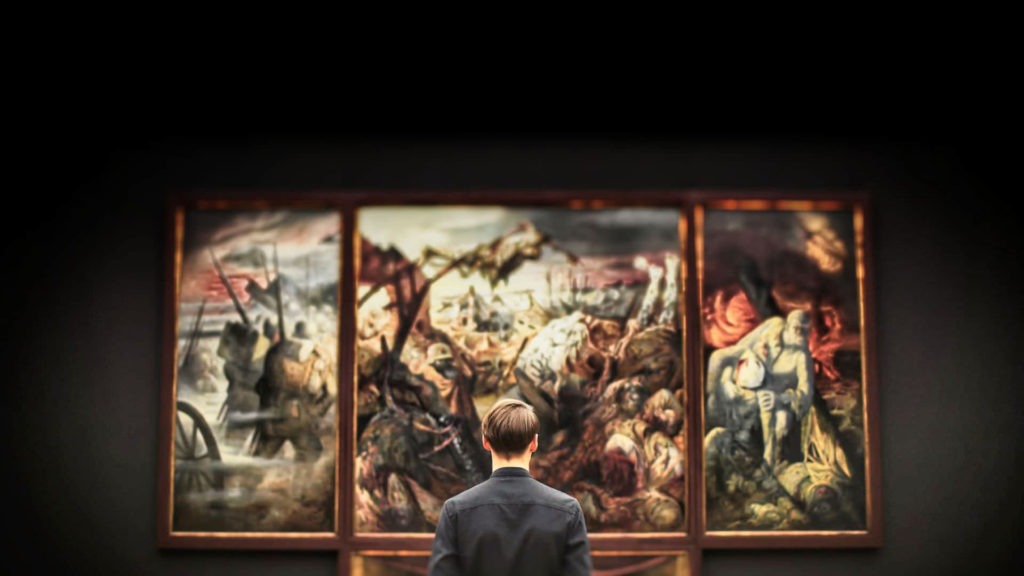 Un homme observe des scènes d'un triptyque (tableau)